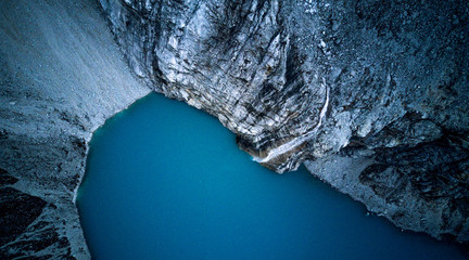 Aerial top down view on blue waters of Laguna 69 at 4800m above the sea level, famous trekking trail at Huascaran National Park in Huaraz, Peru. Small waterfall entering the lake.  © Katarzyna