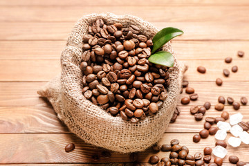 Bag with coffee beans on wooden background