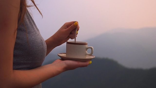 beautiful girl enjoy the organic fresh coffee or masala chai in india hills with top nice view at evening sunset