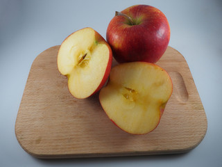 Naklejka na ściany i meble Two red apples on a chopping board