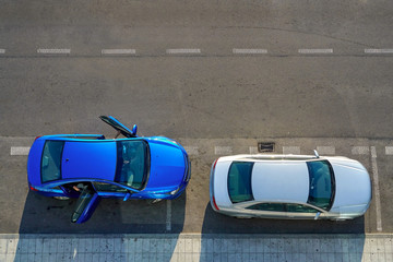 Directly above view of two parked passenger cars, one of them with open door.