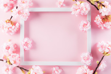 Fototapeta na wymiar Happy Mother's Day, Women's Day or Valentine's Day greeting concept. Pastel Pink Colours Background with picture frame and blossom flowers flat lay patterns.
