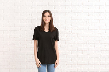 Woman in stylish t-shirt on white brick background