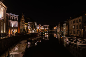 Calm water canal and old medieval buildings at night, Ghent, Belgium