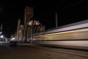  Tram trails on the street of Ghent and monumental column architecture in background, long exposure, blurred motion, city vibe,  Saint Nicholas' Church in the background