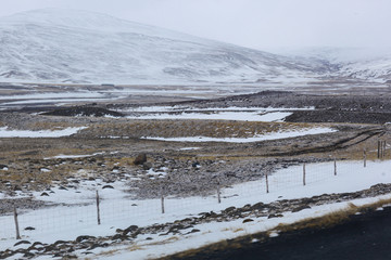 Dark asphalt road on the background of mountains and ocean. The tour around Iceland. Geothermal heat this way