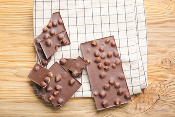 Sweet chocolate with nuts on wooden table
