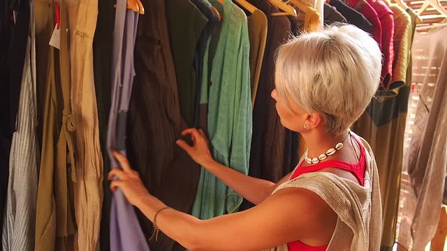fashion consultant short haircut blonde choose dress at clothing store in Bali tropical shop
