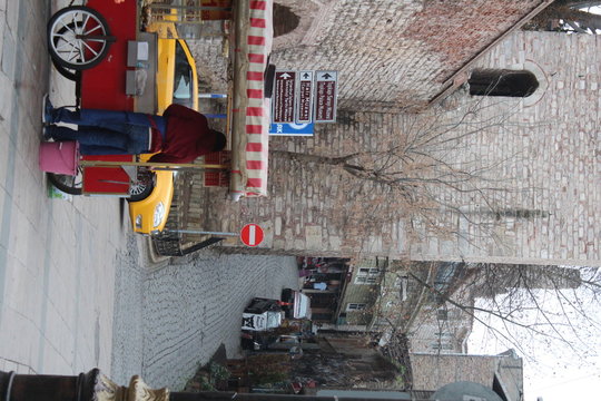 Rear View Of Vendor Standing By Concession Stand On Street In City