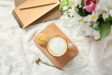 Obraz na płótnie Canvas Cup of coffee, flowers, cookie and notebook on soft plaid