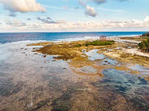 Aerial view of magestic landscape at sunset in the reef of Cloud9 at low tide with coral reef and transparent waters, Siargao Island, Philippines