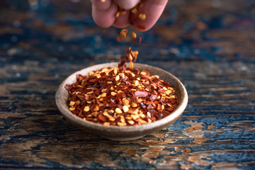 Sprinkling Red Pepper Flakes in a Bowl