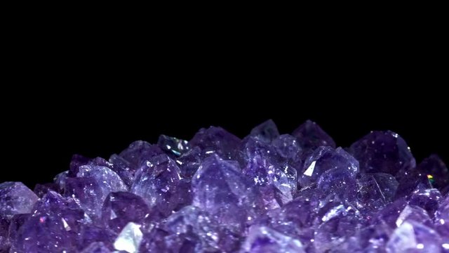 Seamlessly rotating a purple mineral (Amethyst) in front of black background.
