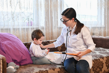 Pediatrician with a small patient at home. inspection of the baby