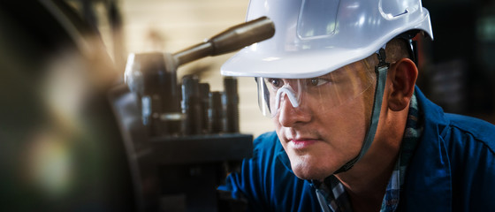 industrial background of caucasian mechanics engineer operating lathe machine for metalwork in metal work factory