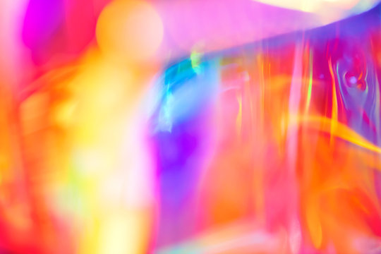 Abstract holographic festive psychedelic pop background of fluid lines and swirls in vibrant neon rainbow colors and glowing light