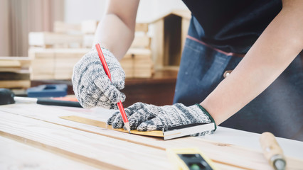 The carpenter working on woodworking machines in carpentry shop. Carpenter work on wood plank in workshop using spokeshave to decorate the woodwork.