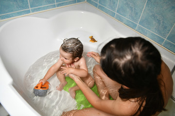 Mom washes the babys head. Joint bathing baby and mom. A symbol of cleanliness and hygiene...