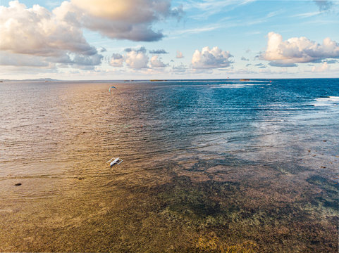 Active surfer practicing kitesurf in Jacking Horse beach close to Cloud9 boarwalk over the reef in low tide, Siargao Island,  Philippines