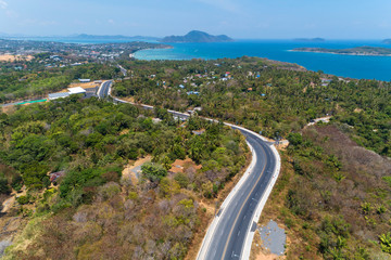 Fototapeta na wymiar Asphalt rural road curve on high mountain with tropical sea in phuket Thailand image by Drone camera High angle view.