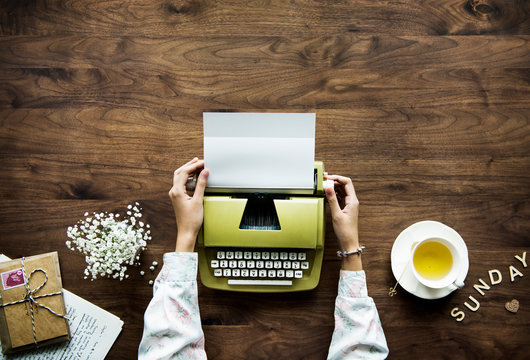 Aerial view a woman using a retro typewriter hobby and sunday leisure concept