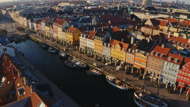 Nyhavn entertainment district in golden sunset with colorful houses from drone