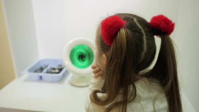 The girl is in the process of treatment of strabismus. Maculostimulator
