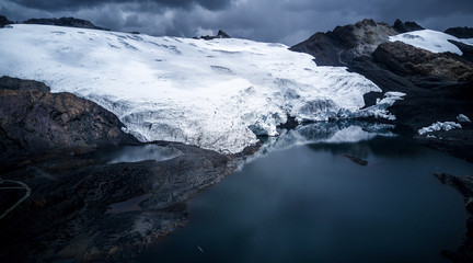 Aerial full view on entire Pastoruri glacier's parts entering the lake, showing how the ice is melting fast due to climate change. Huascaran National Park, 5000m above the sea level, Peru. 