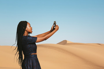 Woman using phone on a desert