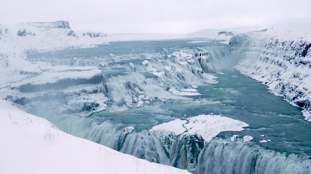 Long shot stunning Gullfoss waterfall during winter covered with ice and snow