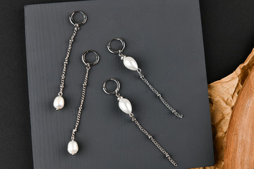 Fototapeta premium silver earrings on a chain. Close-up. Laid out on a wooden stand. View from above. The concept of jewelry and jewelry. Gifts for women. shopping. Handwork.