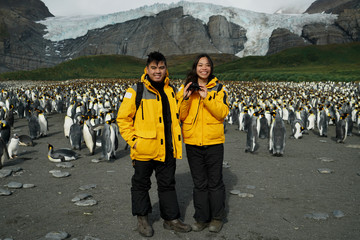 Travelling Couple with Penguins in Backgound