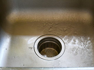 View of the sink, drain and flowing water for background