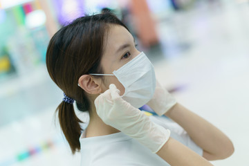 Woman protects herself from infection with the surgical mask and gloves, ready for shopping at supermarket after coronavirus pandemic.