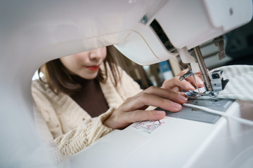 Woman using the sewing machine to sew the face mask during the coronavirus pandemia.