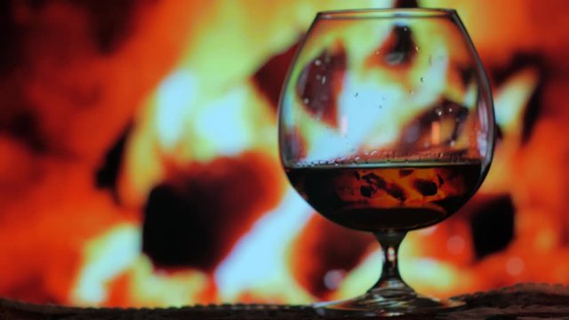 A close up shot taked with vintage lens of a cognac glass in front of the fireplace