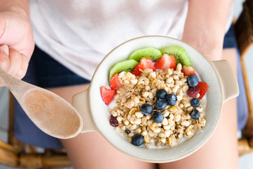 Hand of woman holding bowl of fresh strawberry and yogurt .Concept of healthy diet and weight control