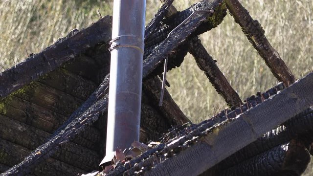 burnt wooden log house, charred wood