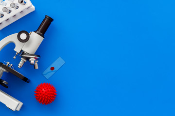 Coronavirus vaccine, research with microscope. Blue background top view copy space
