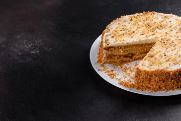 Fresh delicious carrot cake with cream on a dark background