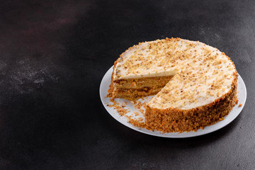 Fresh delicious carrot cake with cream on a dark background