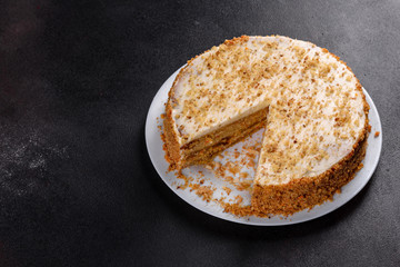Fresh delicious carrot cake with cream on a dark background
