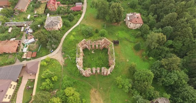 4K aerial summer morning drone video of abandoned dilapidated vintage beautiful white stone and brick mansion among green woods and grassy land built in 18th century totally destroyed nowadays