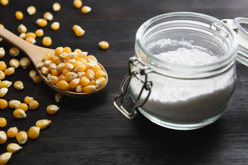 Close-up of corn seed in wooden spoon on black background