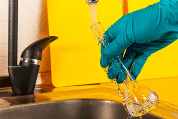 water purification specialist tap water pours into a glass flask.