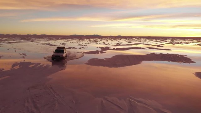 Jeep in salar de uyuni bolivia during sunset