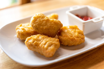 chicken nuggets on white plate with ketchup