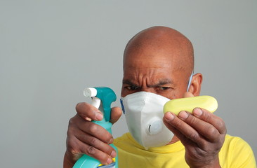 COVID-19 Coronavirus  pandemic global outbreak man with disinfectant spray face mask fighting the disease on grey background stock photo
