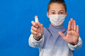 Young man in a sterile mask isolated on blue background. 2019-ncov sars covid-19 concept of influenza virus epidemic of pandemic coronavirus. It symbolizes the obligatory disinfection of hands.