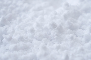 Obraz premium Background of fresh white snow. Winter snowflakes texture. Snow white texture winter background. Icy surface pattern. Shiny snow with bokeh. Macro shot